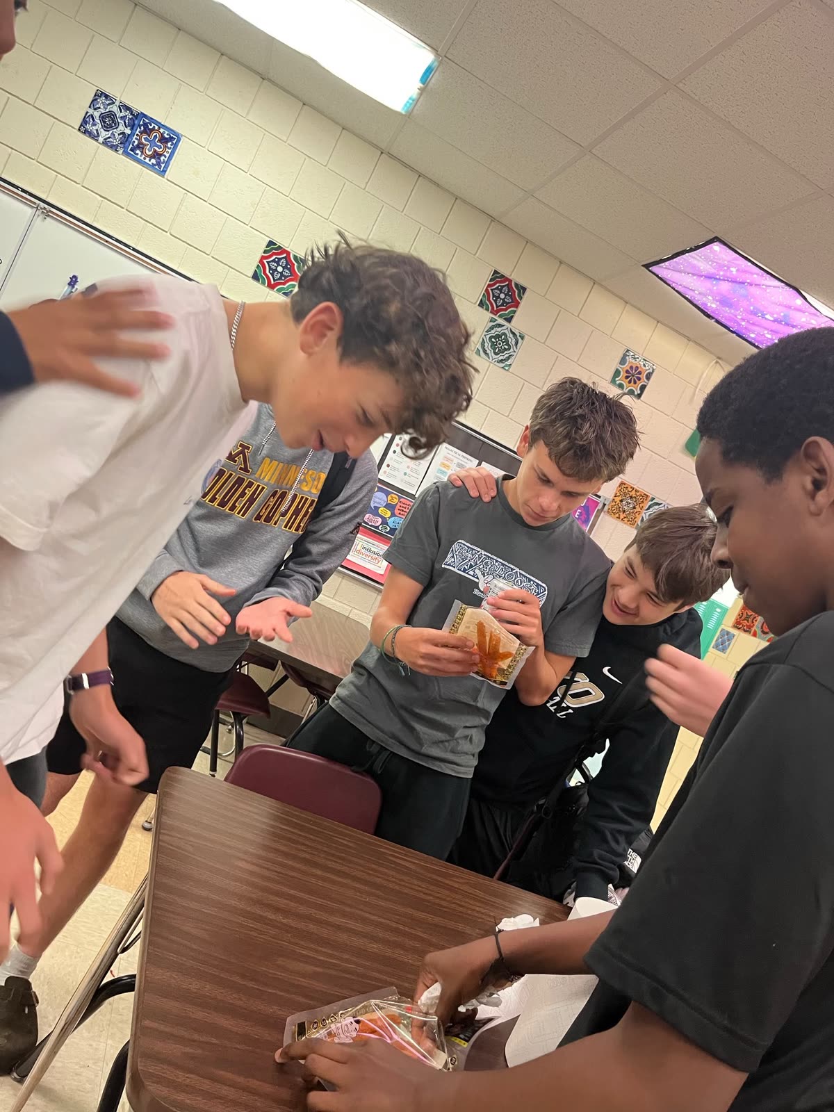 Students crowding around a table to try a snack